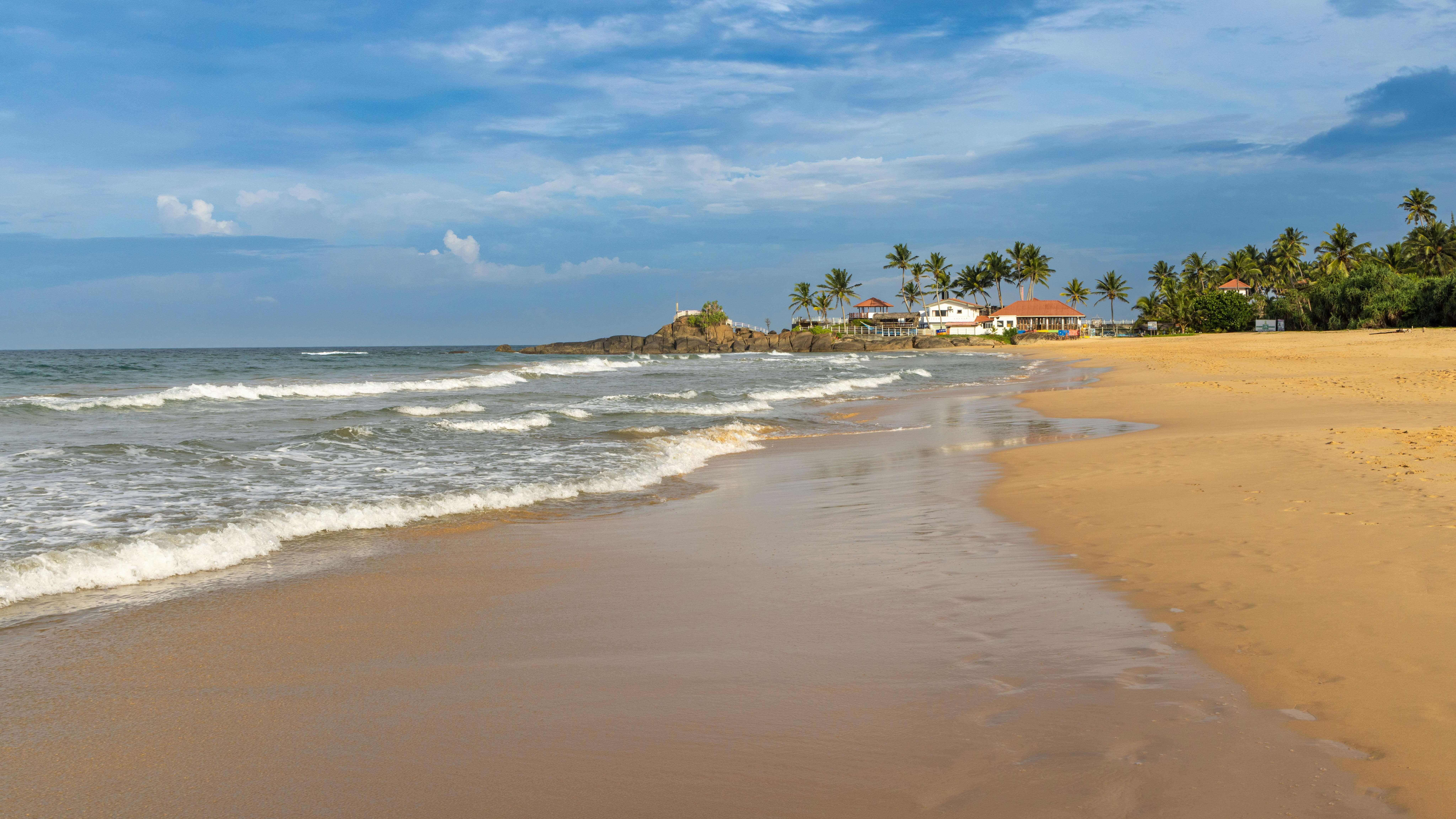 Golden beach and clear blue sky at Bentota Beach Sri Lanka