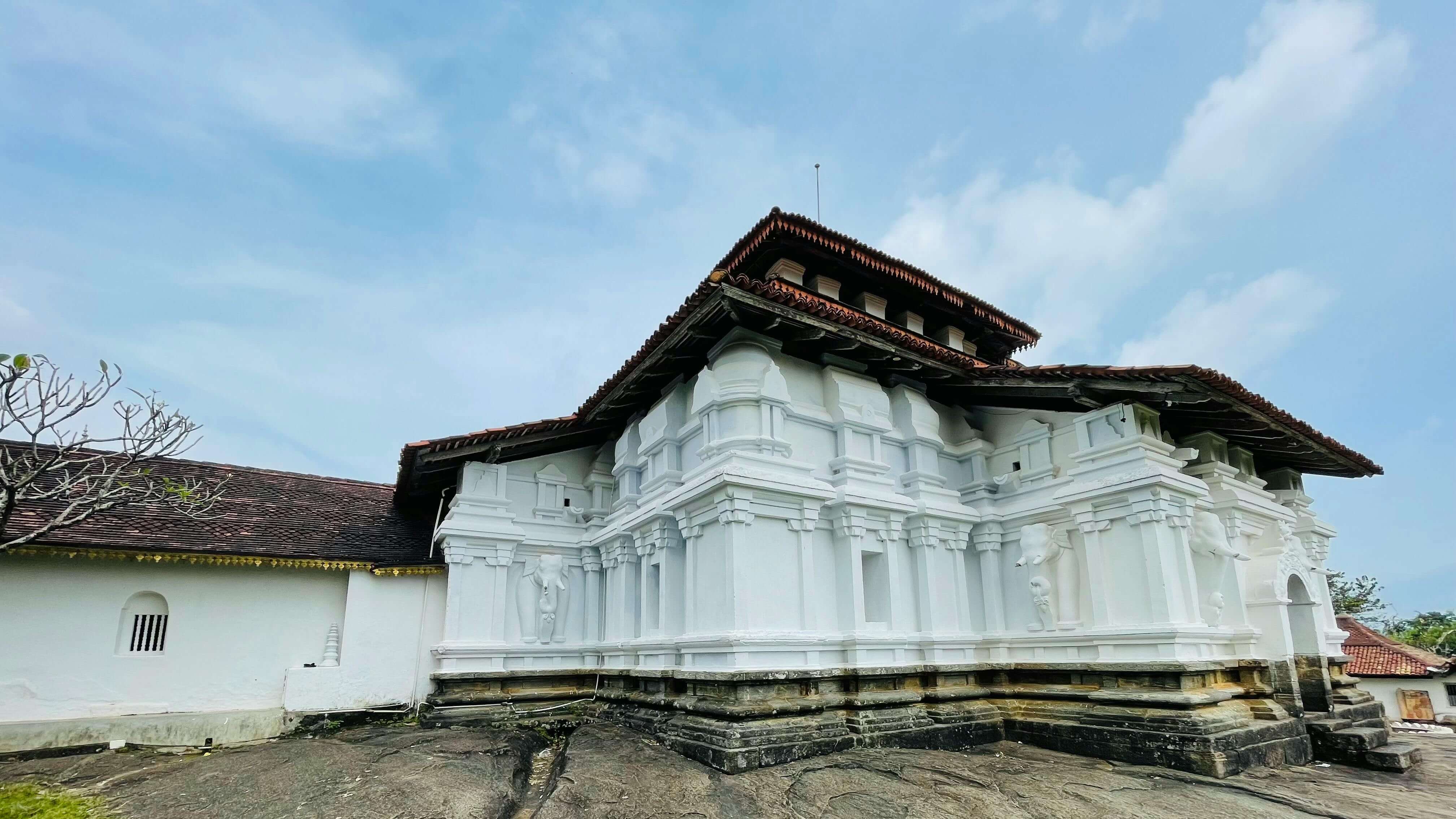 Lankatilaka Temple front view with ancient architecture and serene hillside background in Sri Lanka